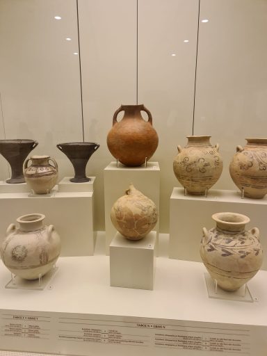 Mycenae Archaeological Site, Greece Various ancient pottery pieces displayed on museum shelves.